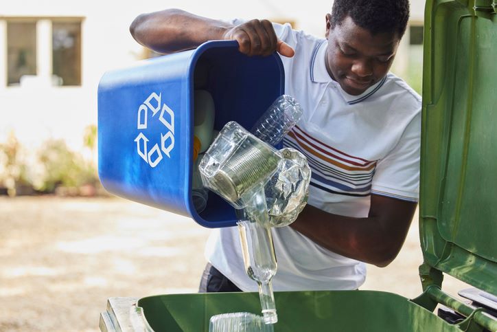 man emptying recycling into bin